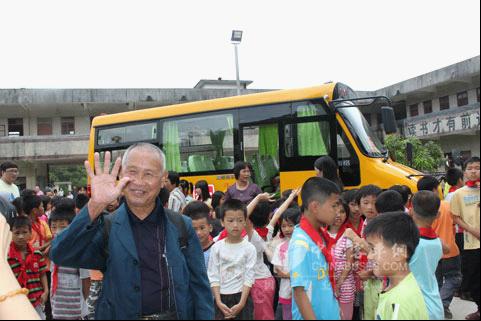 The group photo of Shijiu Gong, the children and Higer bus